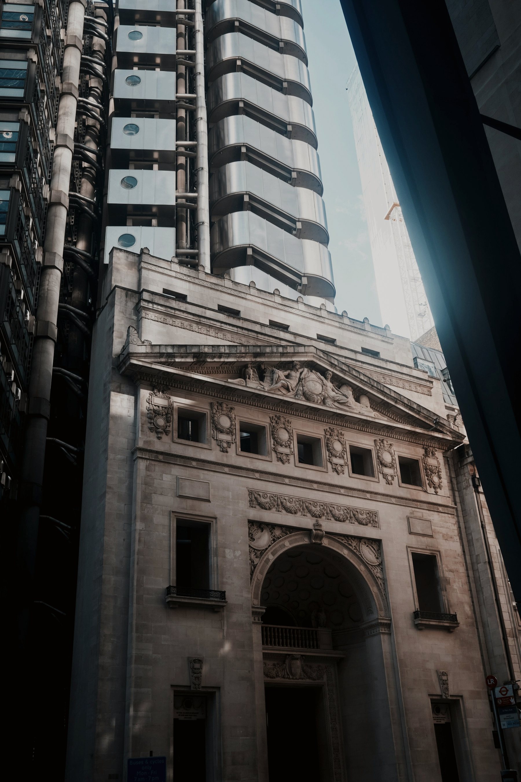 The Lloyd's building rising directly behind a classical Portland stone facade in the City of London.